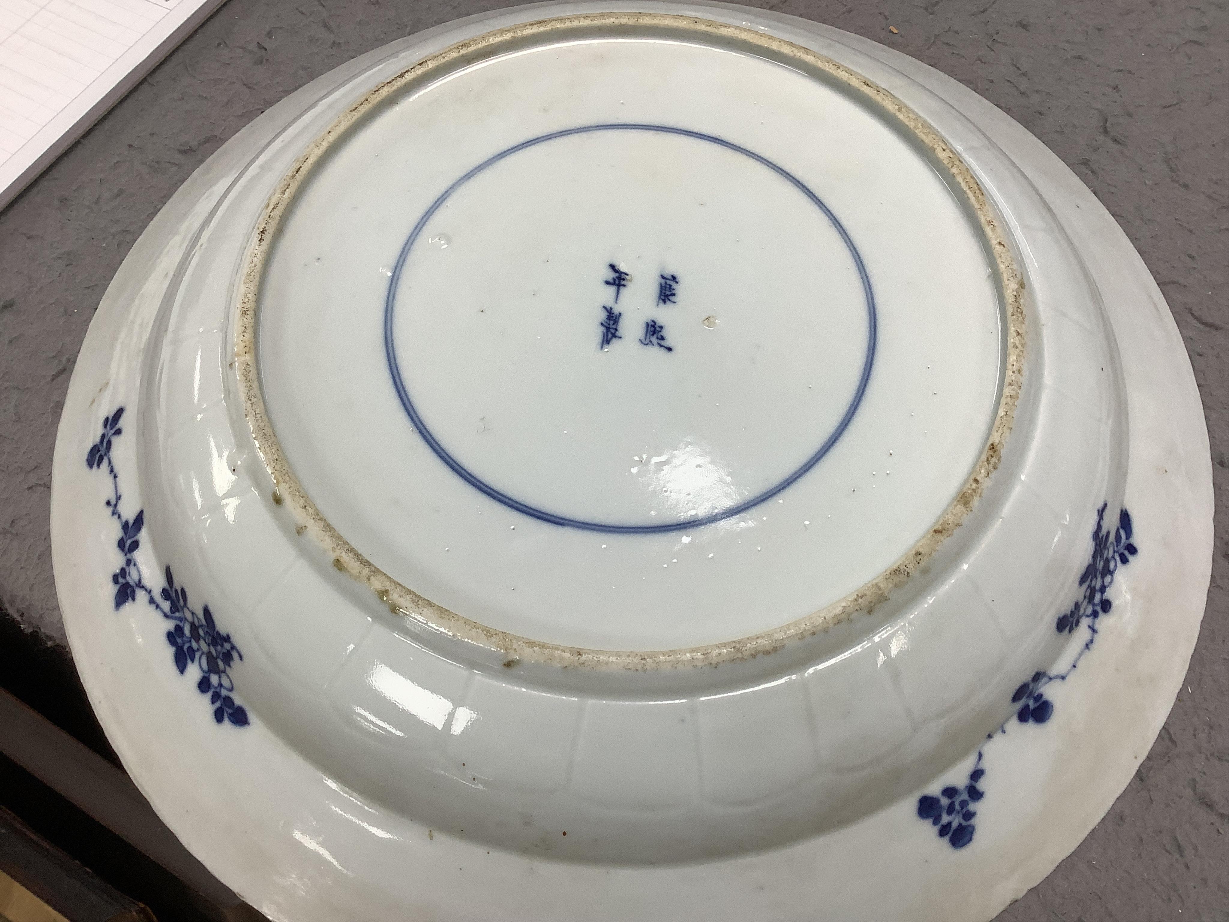 A Chinese blue and white 'fish' dish, Kangxi mark but c.1900, 33cm diameter. Condition - slight chipping to rim